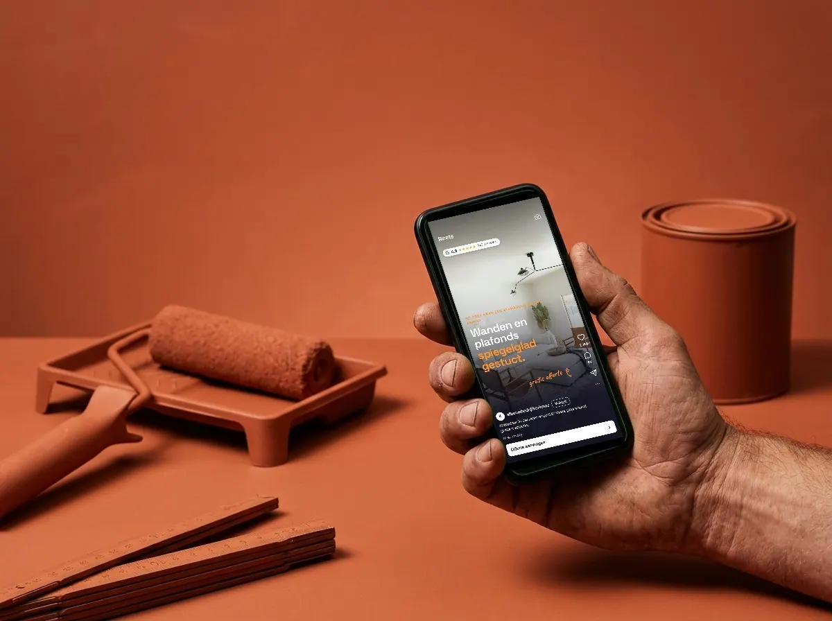Vakman houdt een telefoon vast met een Reels-advertentie van een stukadoor