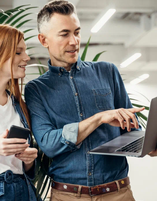 Twee collega's kijken samen naar een laptop